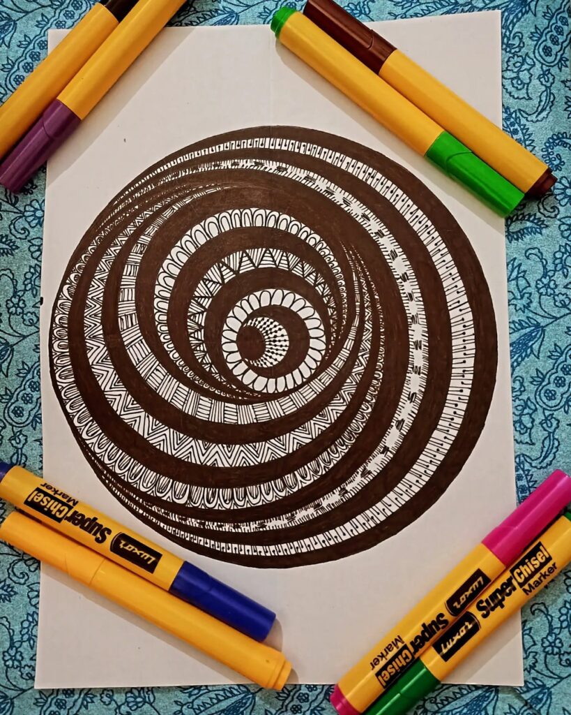 A table with a drawing made with markers and pens.